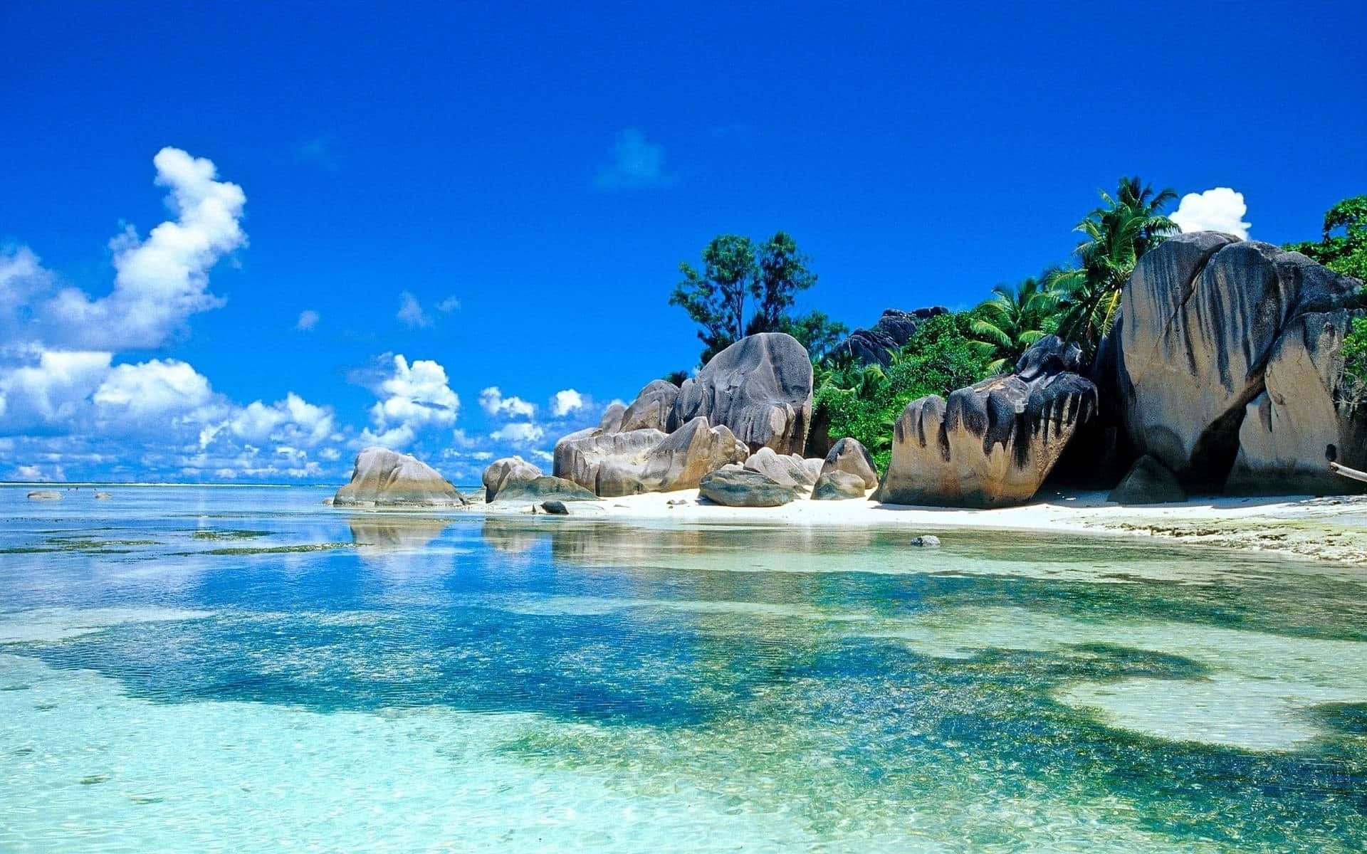 熱帶海灘，碧綠海水和巨石，天空湛藍。