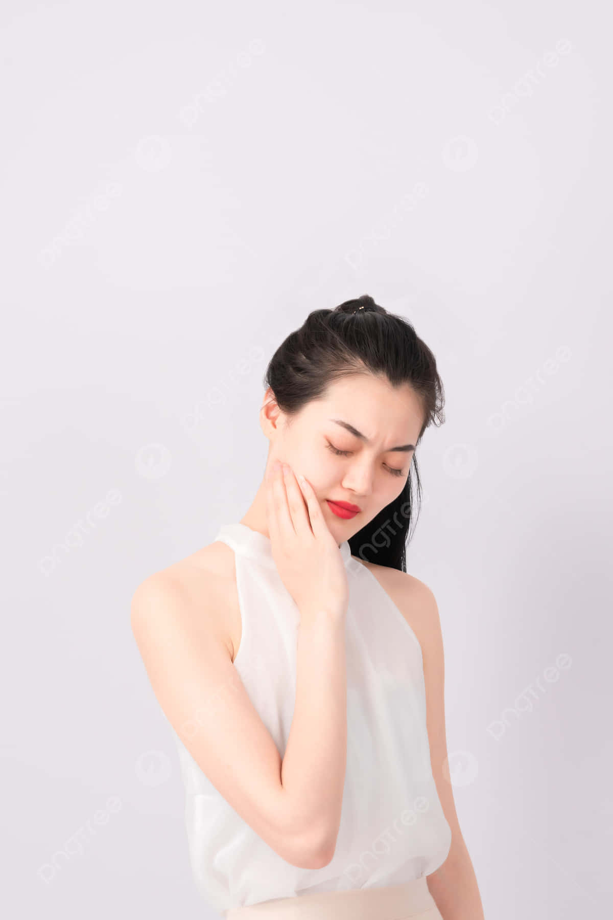 身穿白色上衣的女性在攝影棚中觸碰臉頰