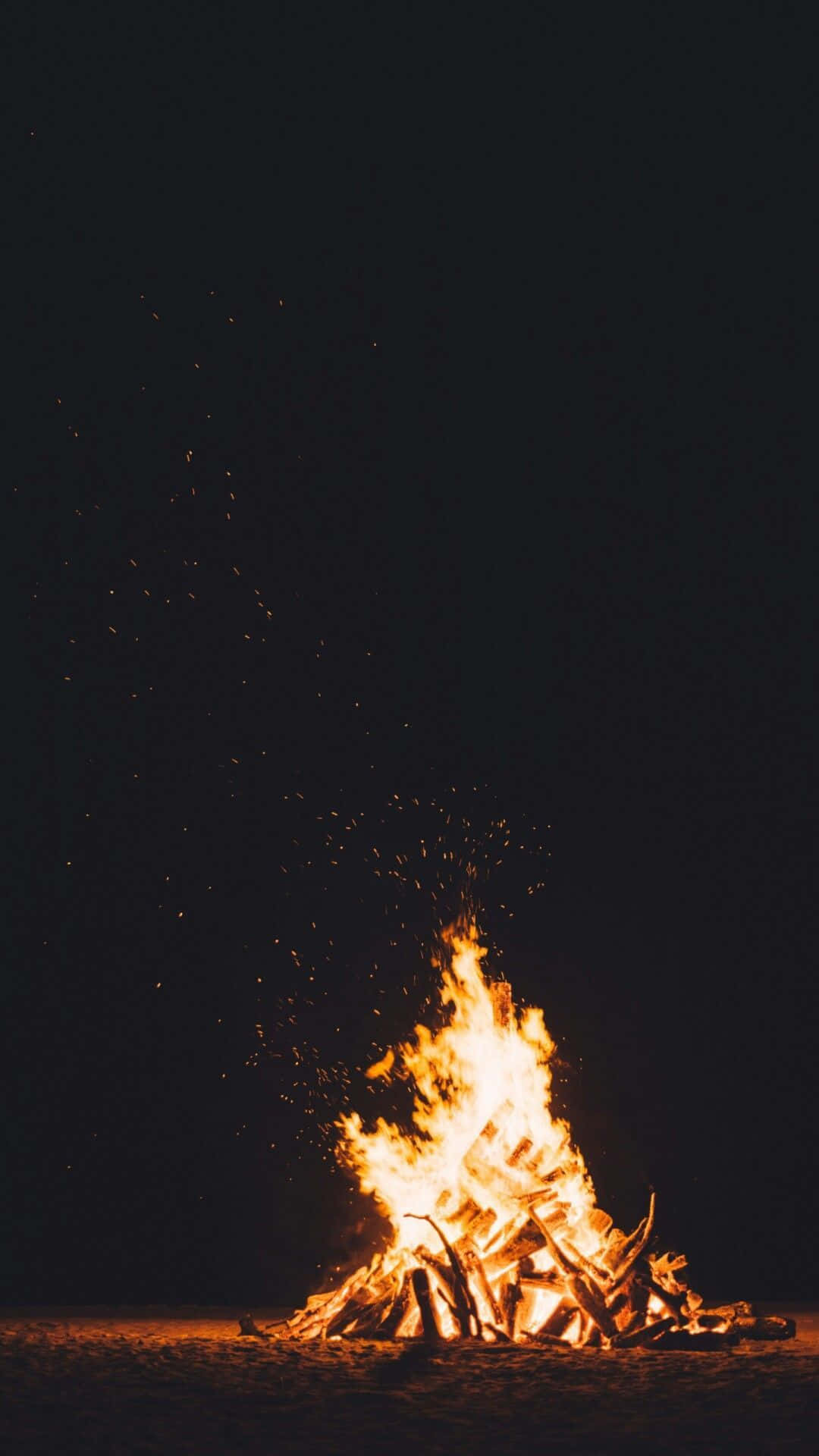 夜晚充滿活力的營火，火花向上飛舞。