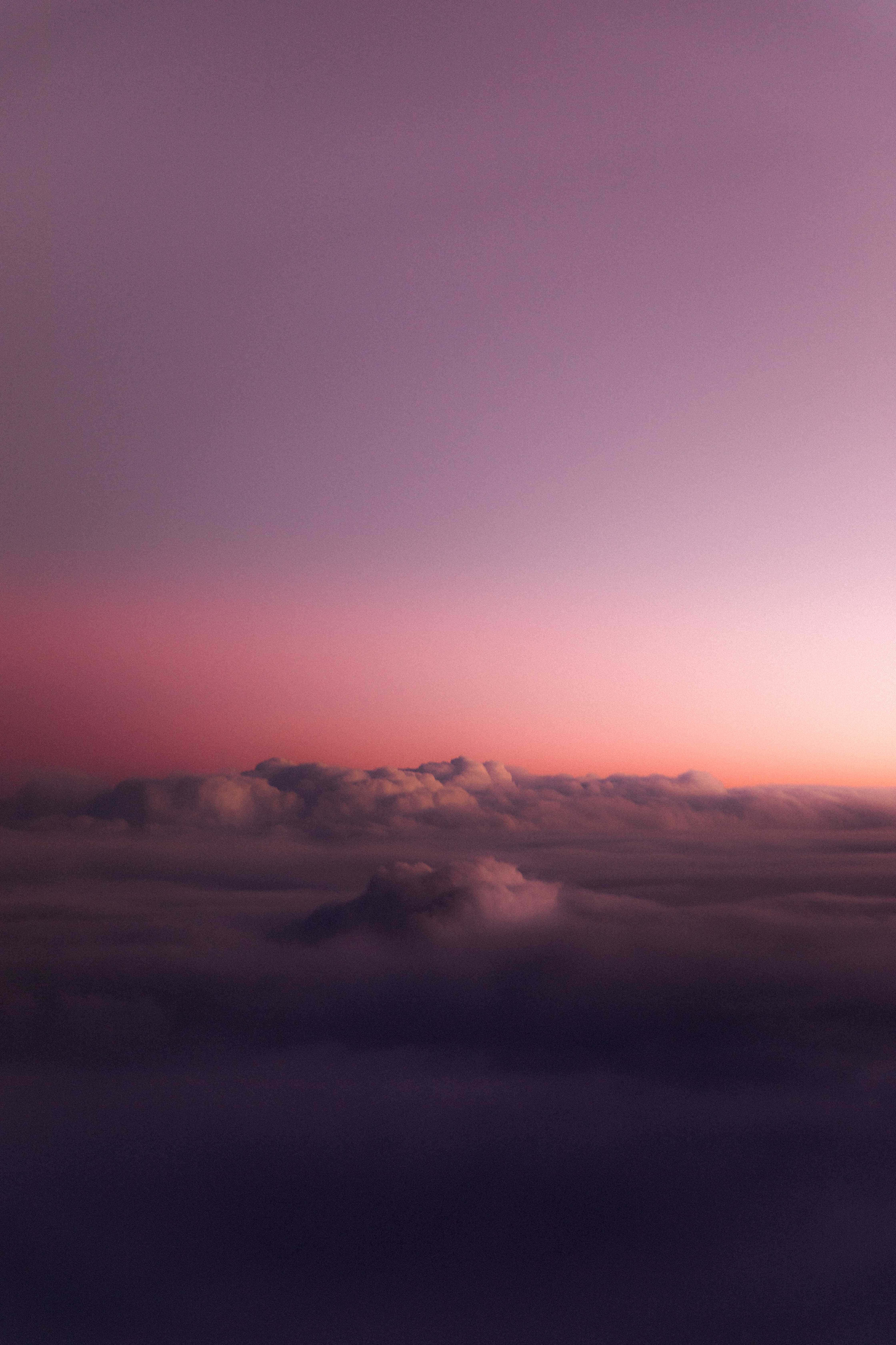 感受自然的寧靜 壁紙 — 暮色中雲海之上，一片寧靜的紫色與粉紅色天空漸變。