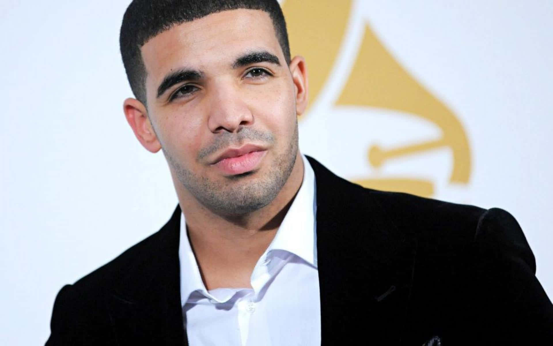 Drake 在格林美獎活動中穿著黑色天鵝絨西裝外套和白色襯衫。