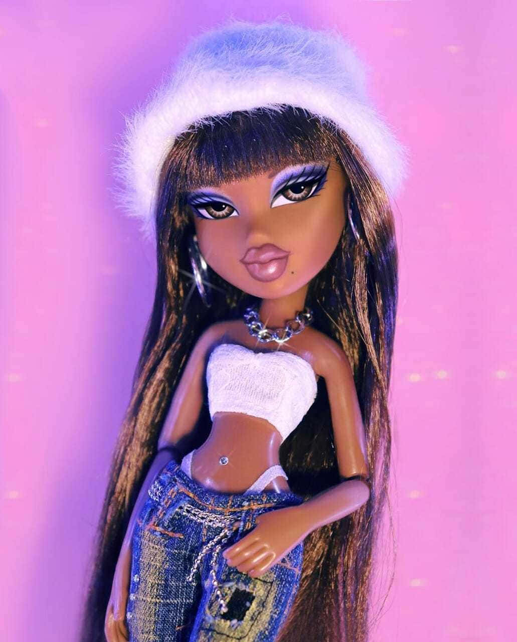 Bratz 公仔穿著牛仔褲和絨毛帽，背景為發光的粉紅色。