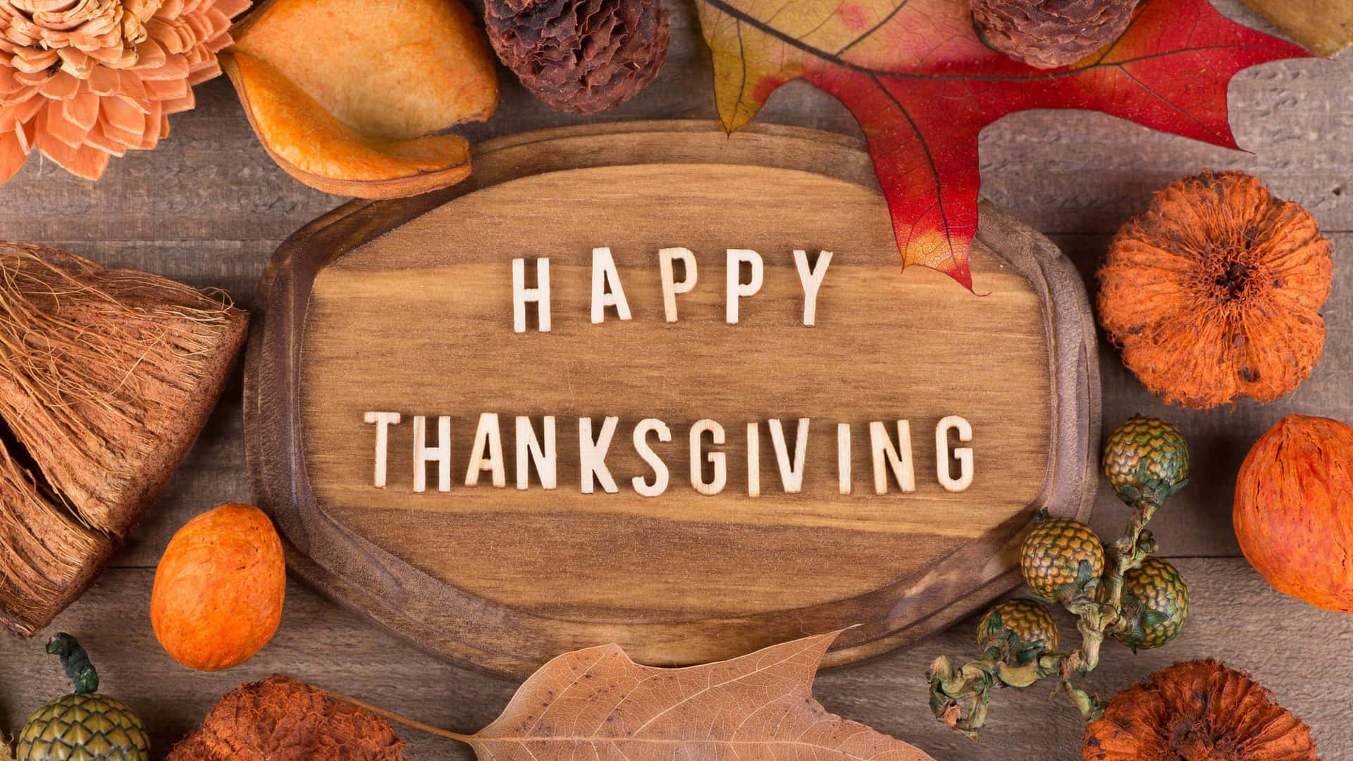 寫有「HAPPY THANKSGIVING」的木牌，周圍環繞著秋葉和葫蘆。