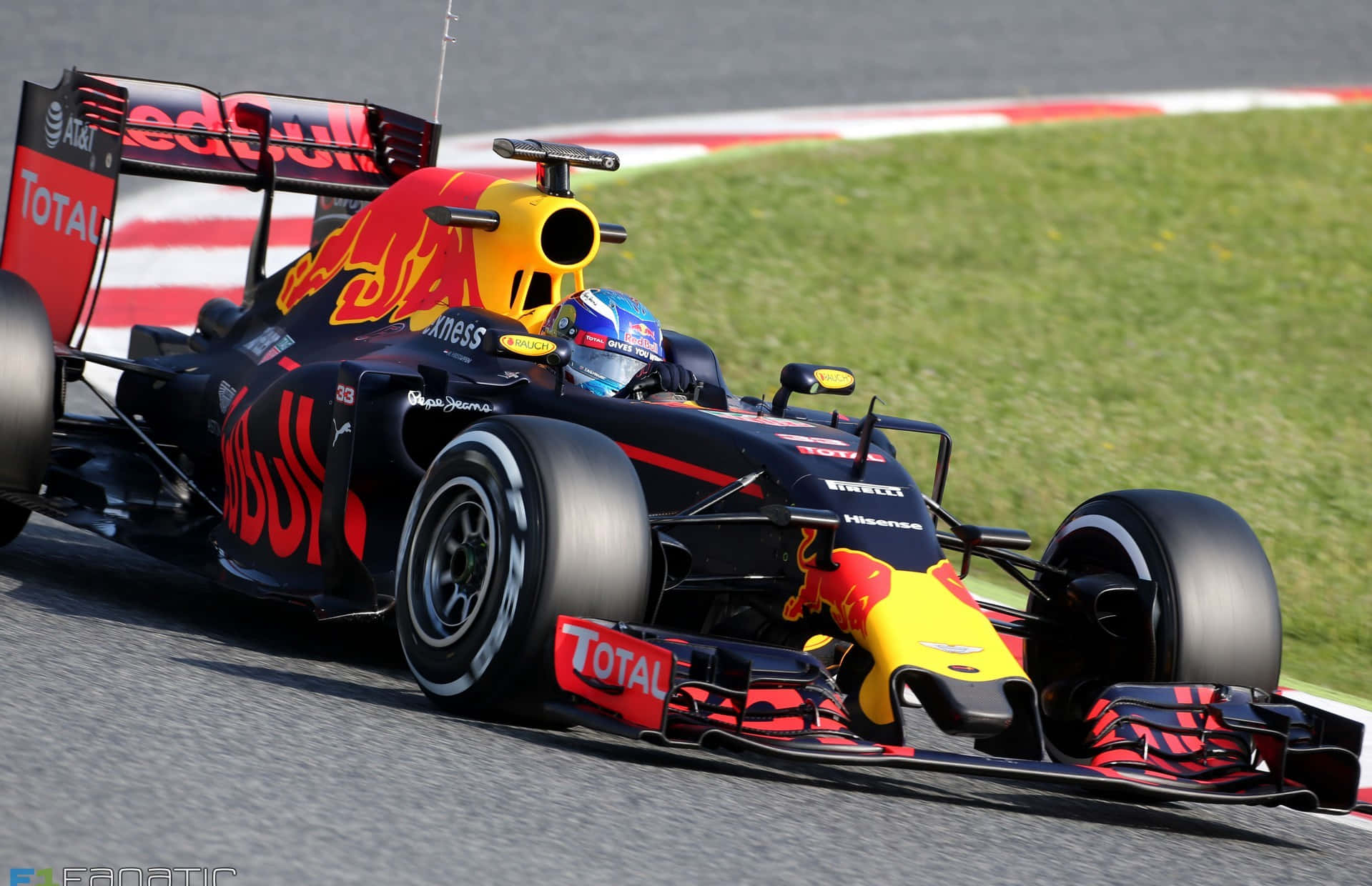 慶祝 F1 2016 的驚險刺激 壁紙 — 一輛紅牛一級方程式賽車在賽道上疾馳，駕駛艙內可見戴頭盔的車手。