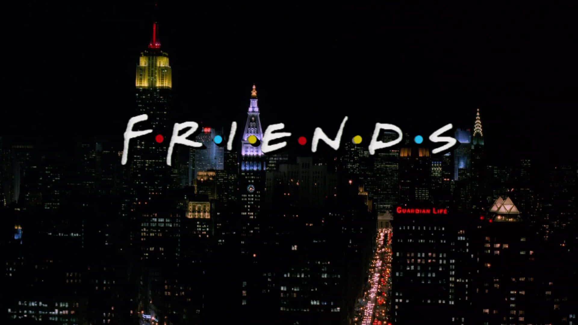 慶祝《Friends》的歡笑、愛情與友情 壁紙 — 標誌性的《老友記》標誌在充滿活力的夜間紐約市天際線上閃耀，照亮了摩天大樓和繁華的街道。