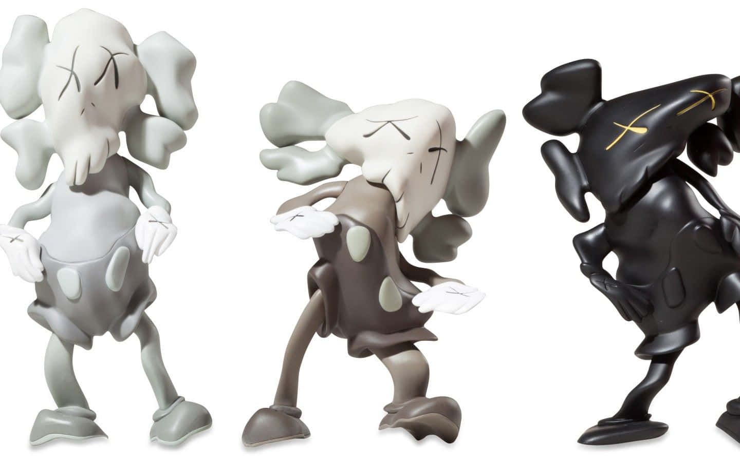 三個KAWS Companion雕塑，灰色、棕色和黑色，白色背景。