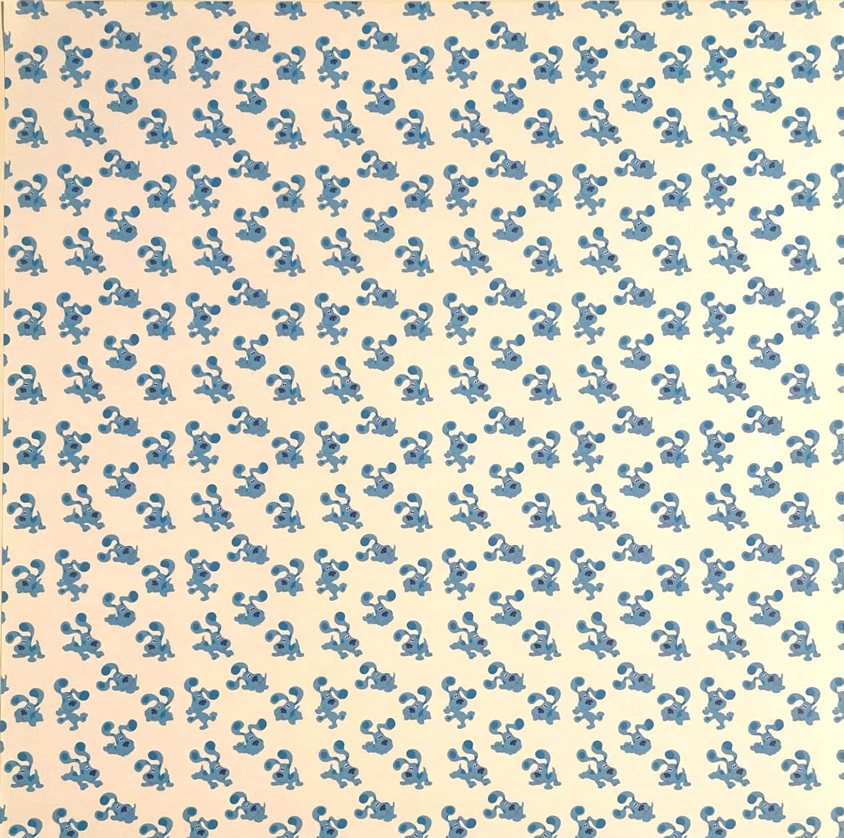 慶祝《藍色小犬》的歡樂與學習 壁紙 — 在奶油色背景上，藍色卡通松鼠拿著橡果的重複圖案。