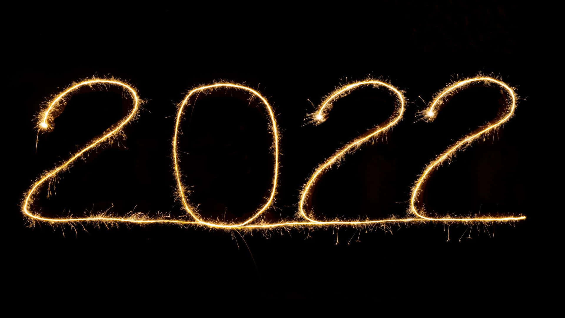 金色煙火在黑色背景上寫出2022年。
