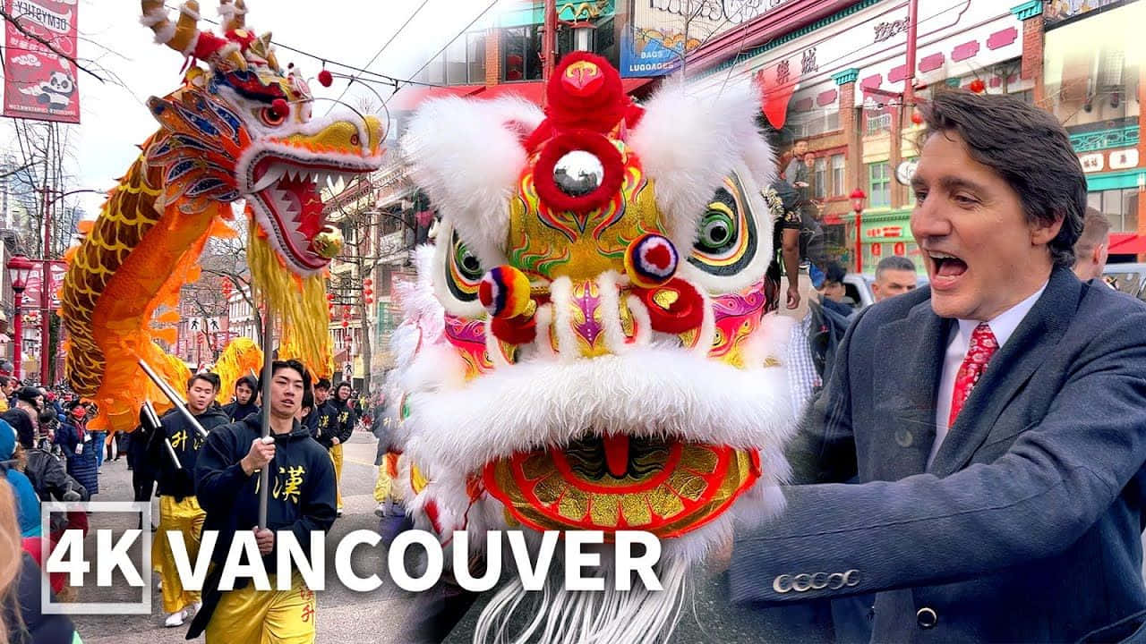 慶祝充滿活力的中國新年傳統 壁紙 — 在溫哥華熱鬧的街頭節日中，一名身穿西裝的男子在色彩繽紛的舞獅服裝旁開懷大笑。
