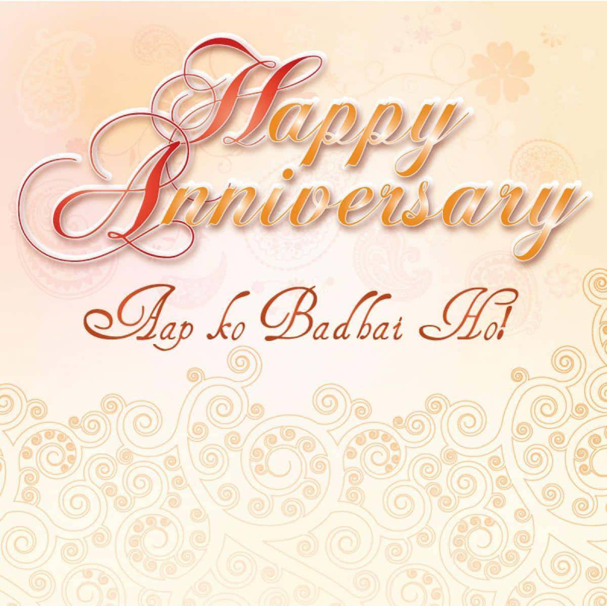慶祝又一年的相伴 壁紙 — 在奶油色背景上，以華麗的漩渦圖案襯托，優雅的週年紀念問候，包含草書「Happy Anniversary」和「Aap ko Badhai Ho!」。