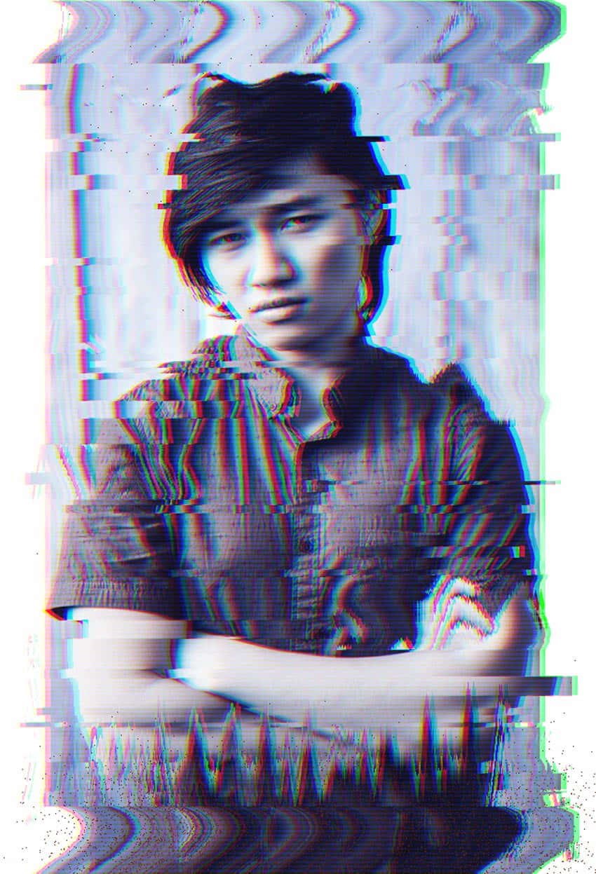 慶祝故障的喜悅 壁紙 — 一個年輕男子交叉雙臂的故障藝術肖像，被數碼噪點和色差扭曲。