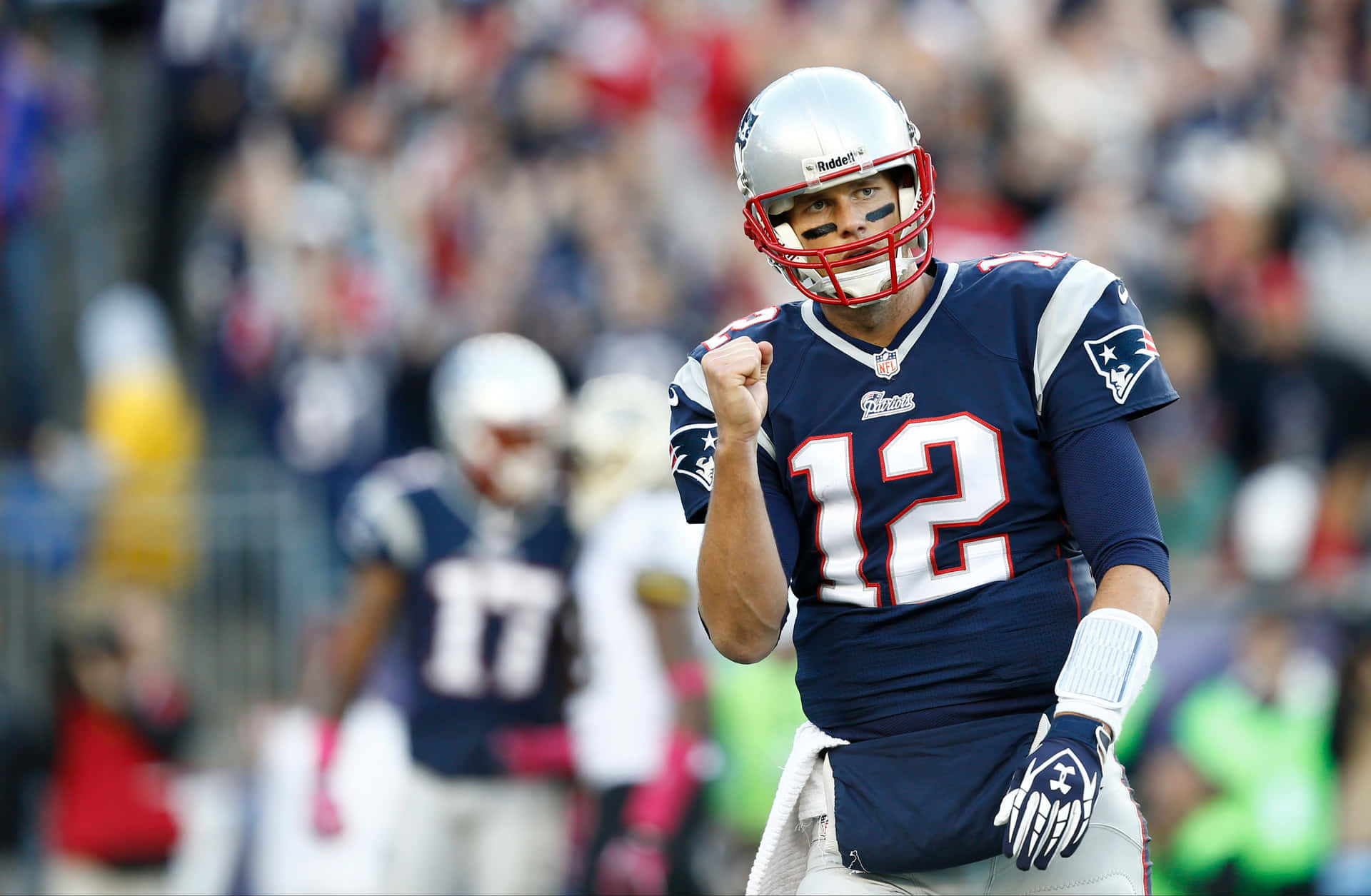 12號美式足球員在比賽中舉拳慶祝。