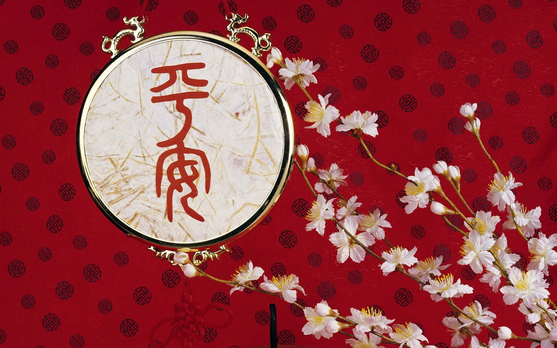 慶祝牛年中國新年 壁紙 — 一個圓形金框書法牌匾，上面有紅色漢字，放置在一個飾有精緻白色櫻花的紅色圖案背景上。