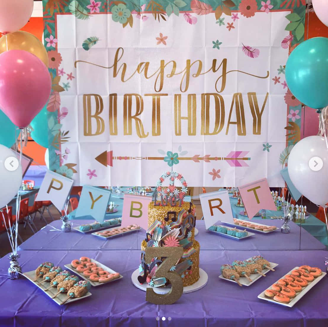 慶祝生命！ 壁紙 — 一個充滿活力的生日派對餐桌，上面有一個閃閃發光的數字三形狀蛋糕，周圍環繞著彩色氣球和各種美食，下方有花卉橫幅。