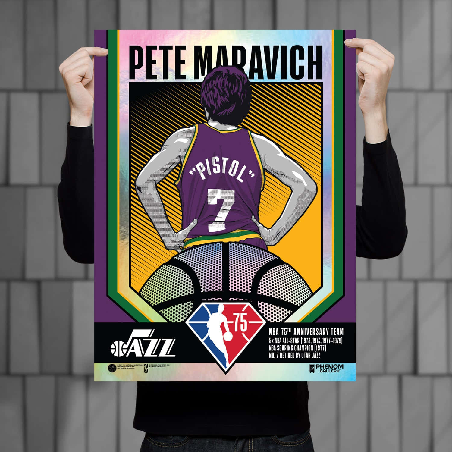慶祝皮特·馬拉維奇——NBA 75週年紀念海報 壁紙 — 一個人手持一張色彩鮮豔嘅Pete Maravich海報，佢着住紫色「Pistol」波衫，攞住籃球，周圍係彩色幾何邊框。