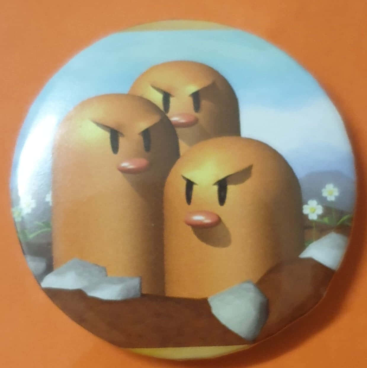 三個憤怒嘅Goomba角色從一個有花嘅土堆中探出頭來。