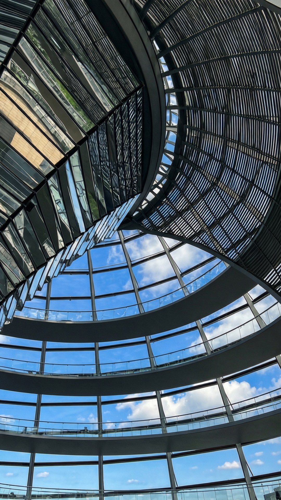 螺旋形玻璃和鋼製圓頂，透過透明面板可見藍天白雲