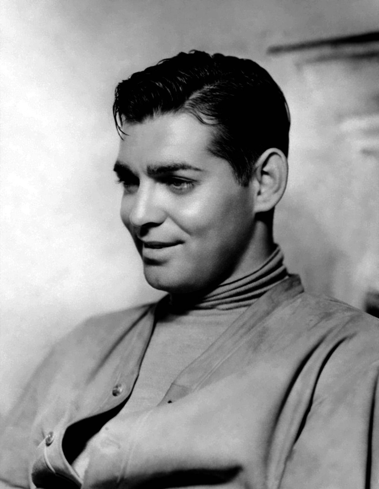一個穿著高領毛衣微笑的男士，在復古工作室肖像中。