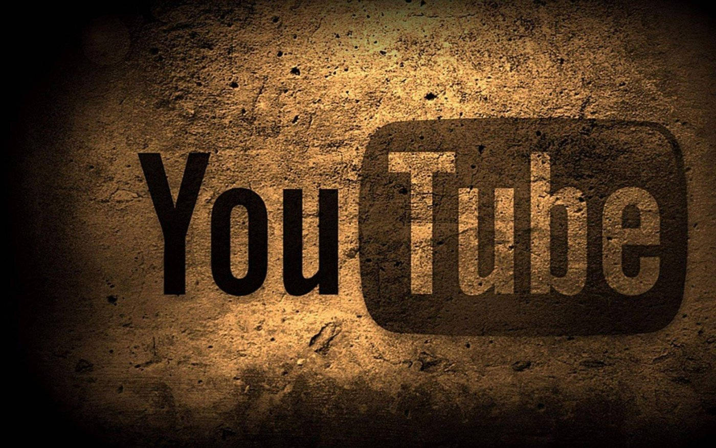 在溫暖聚光燈下，粗糙混凝土牆上繪製的 YouTube 標誌。