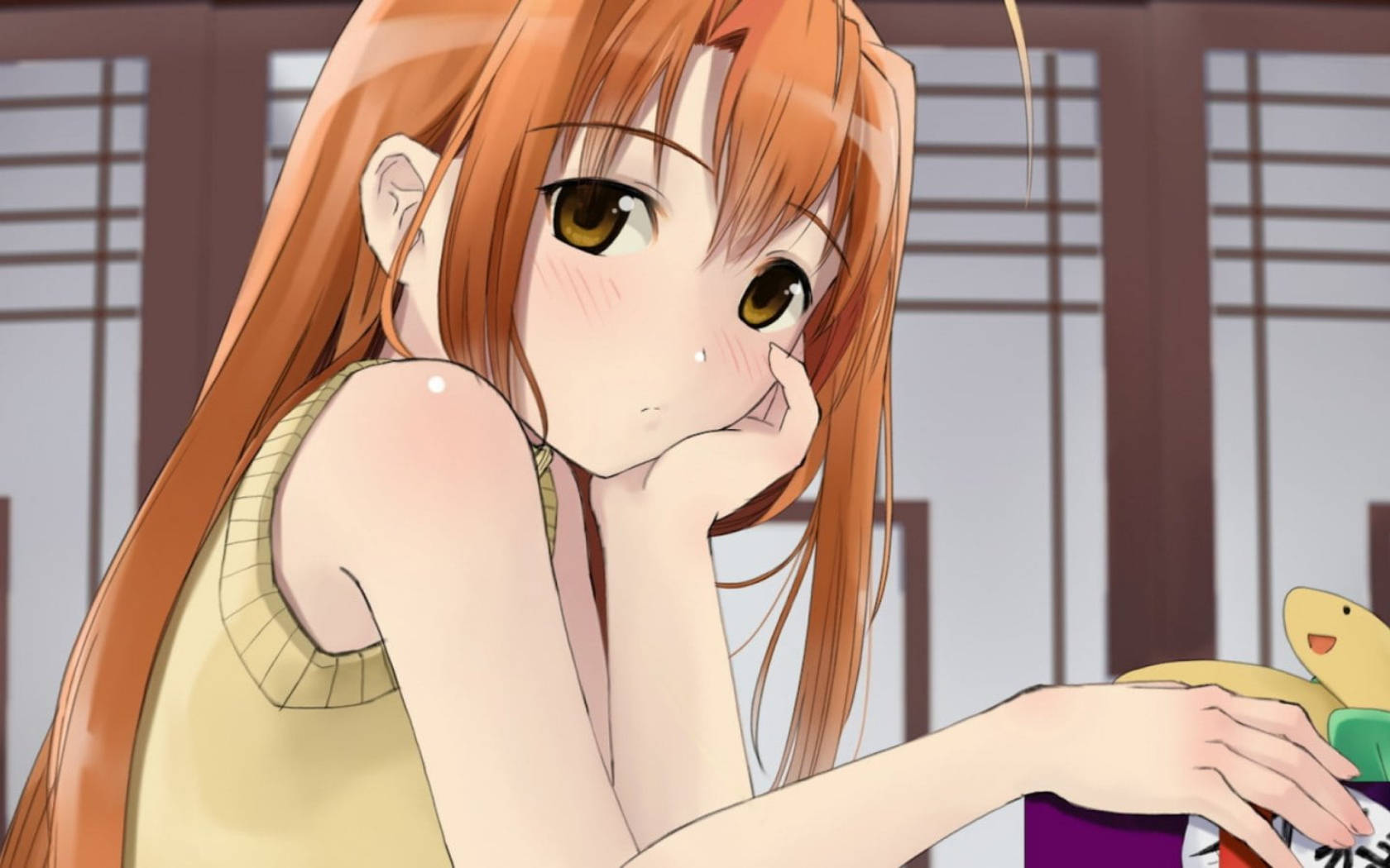 《戀愛小魔女》年輕的鳴子 壁紙 — 長橙髮動漫女孩在室內用手托著下巴，同時拿著一個色彩繽紛的毛絨玩具。