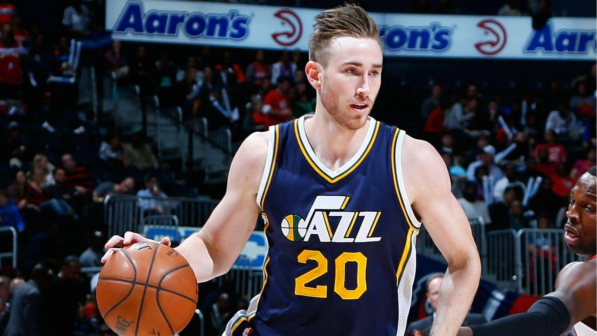戈登·海沃德NBA爵士隊運球 壁紙 — 一名身穿爵士隊球衣的籃球運動員在明亮的場館燈光下，於激烈的比賽中運球。