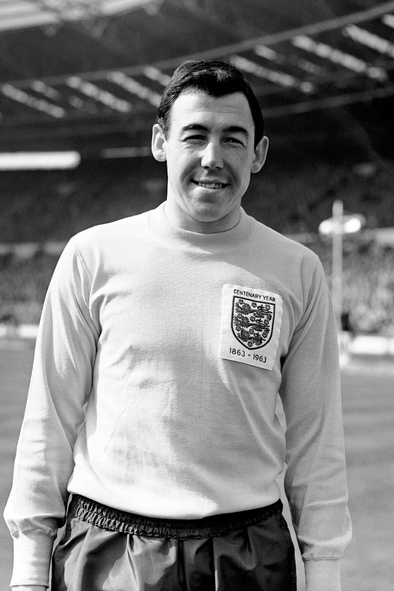 英格蘭足球員穿著1963年百周年紀念球衣在球場草地上微笑