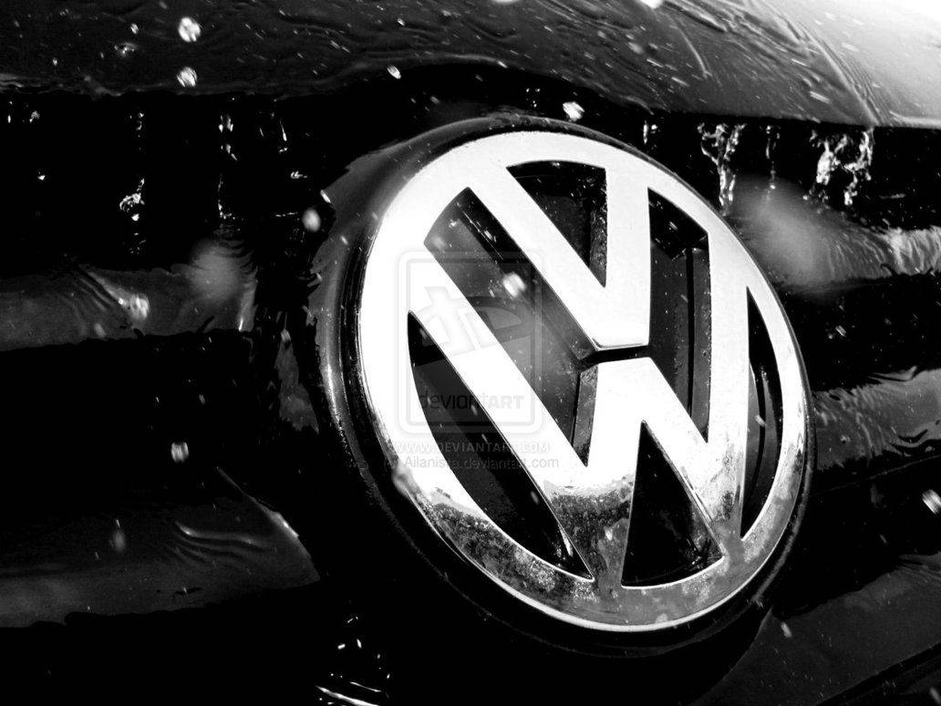 Volkswagen 標誌在濕潤的汽車引擎蓋上，帶有水珠和飛濺。