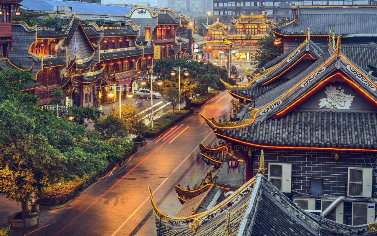 夜晚的傳統中國建築，濕漉漉的街道和車燈軌跡。