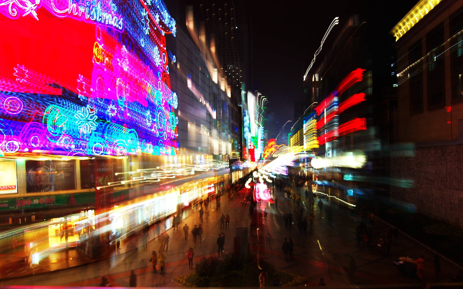 夜間城市街道，帶有模糊燈光和聖誕裝飾。