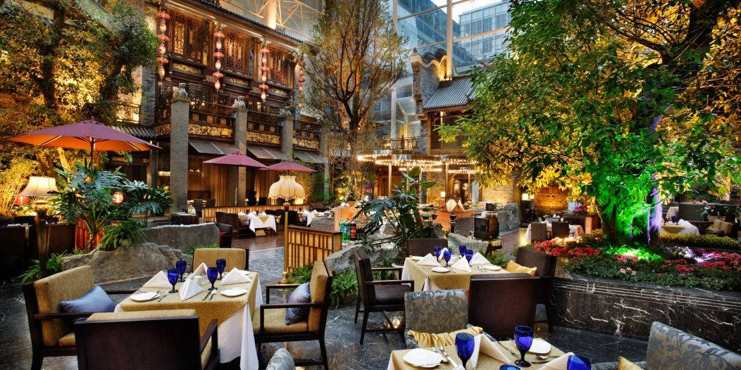 豪華室內庭院餐廳，配有餐桌、燈籠和綠色植物。