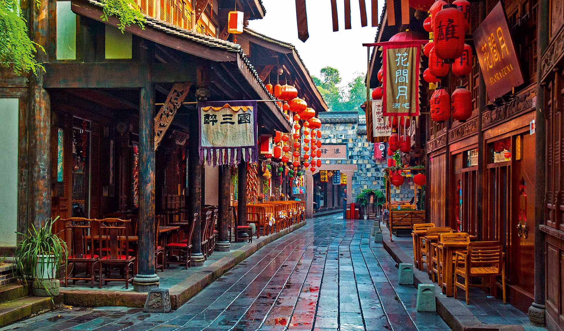 傳統中國街道，紅燈籠和木建築在潮濕的石板路上。