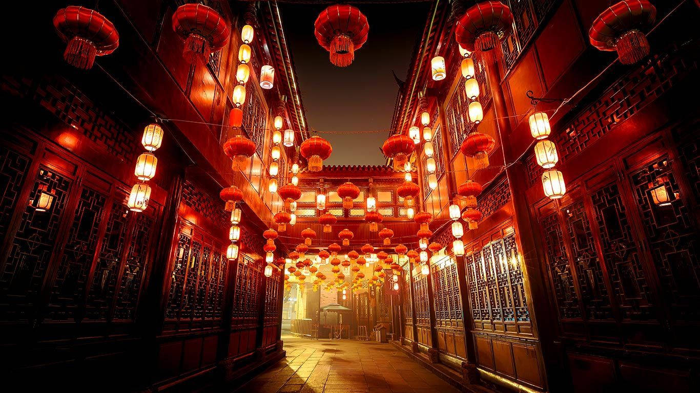 夜晚一條狹窄的小巷，被發光的紅燈籠照亮。
