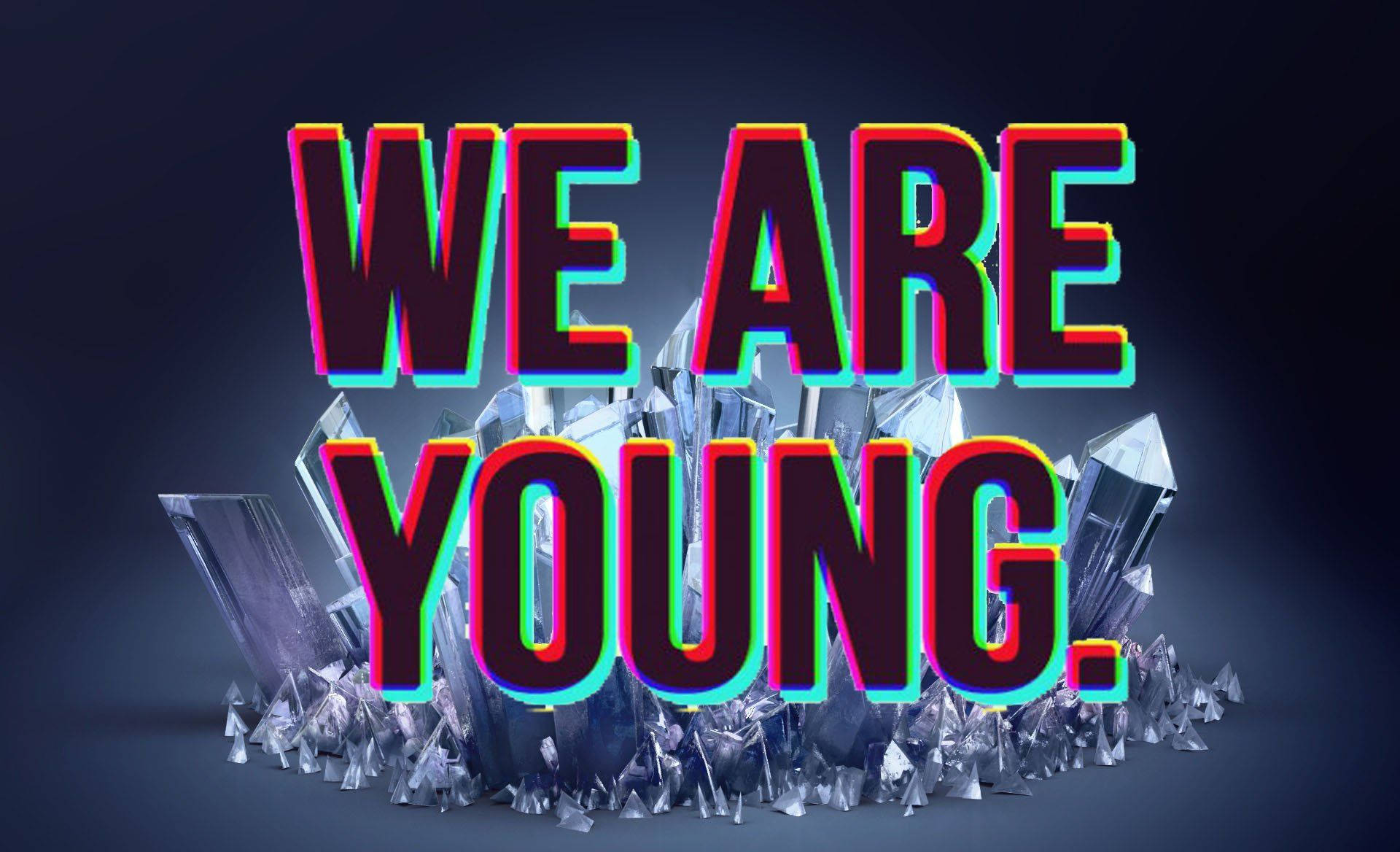在深色背景上，從水晶碎片中升起的霓虹發光文字 WE ARE YOUNG。