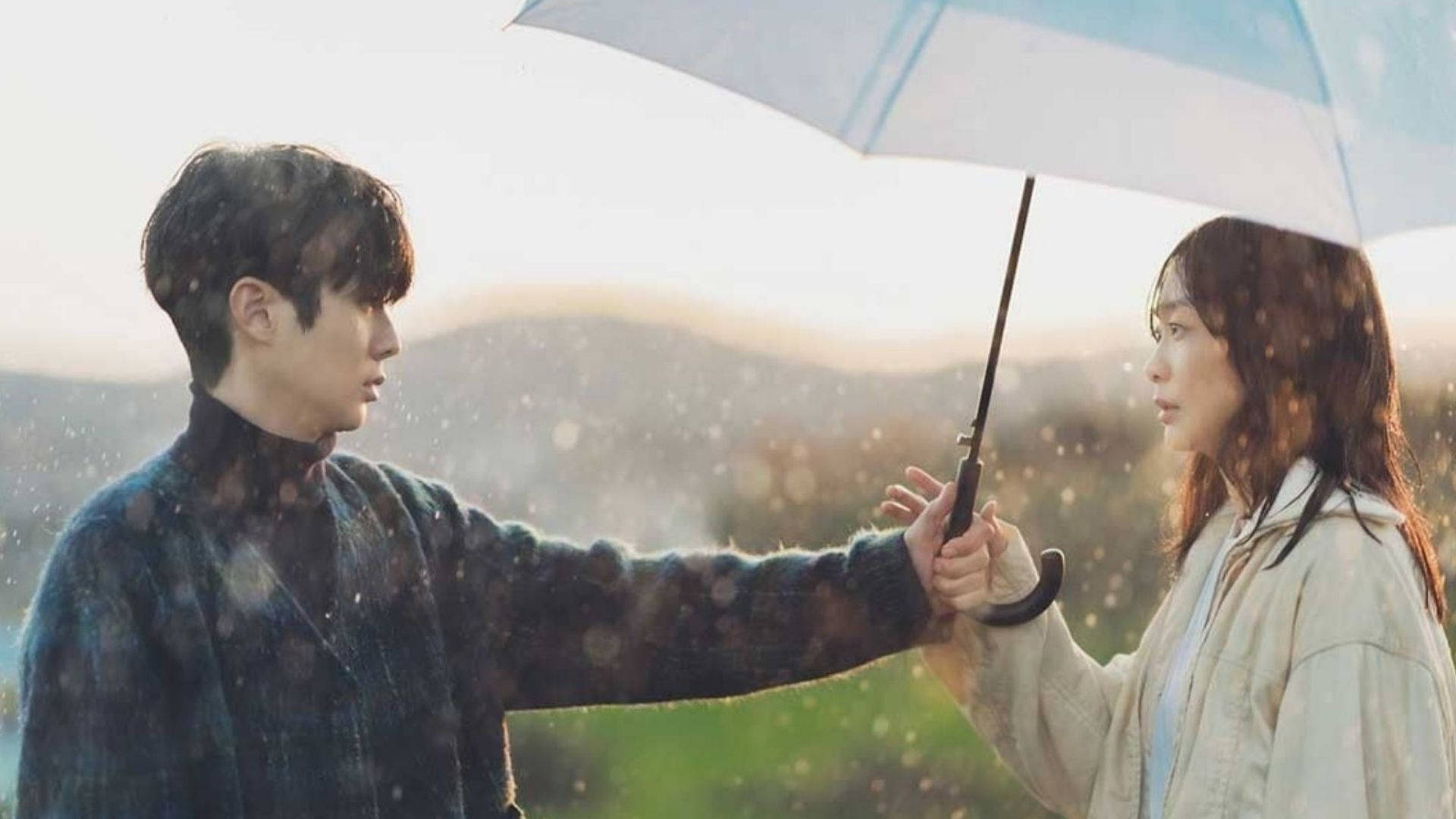 一對情侶在黃昏時分在雨中共用一把傘