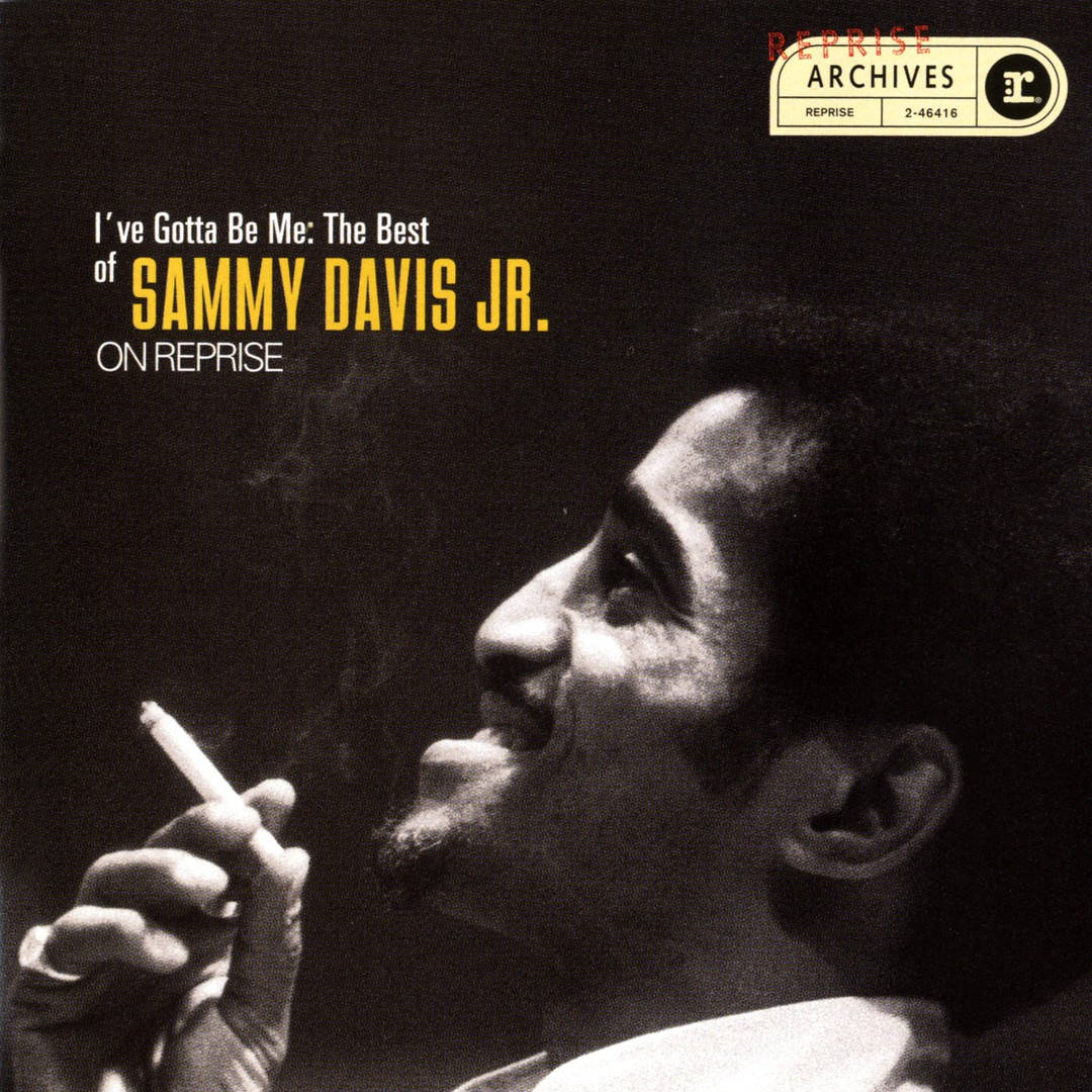 Sammy Davis Jr. 在黑白照片中微笑著拿著一支香煙。