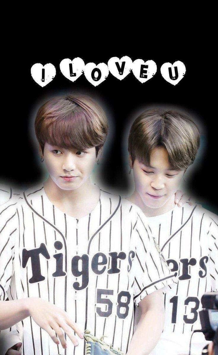 我愛你 Jikook 壁紙 — 兩位身穿棒球衣的年輕男子，上方有心形字母 'I LOVE U'，背景為黑色。