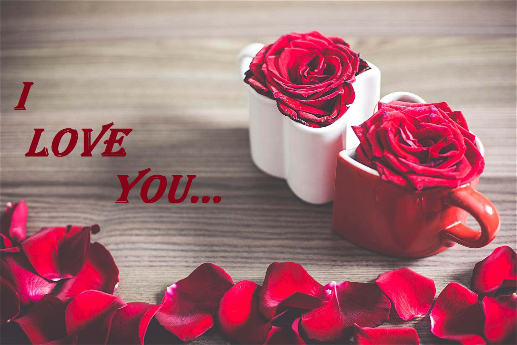我愛你 壁紙 — 兩朵紅玫瑰在馬克杯中，散落花瓣和「I LOVE YOU...」文字在木質表面上。