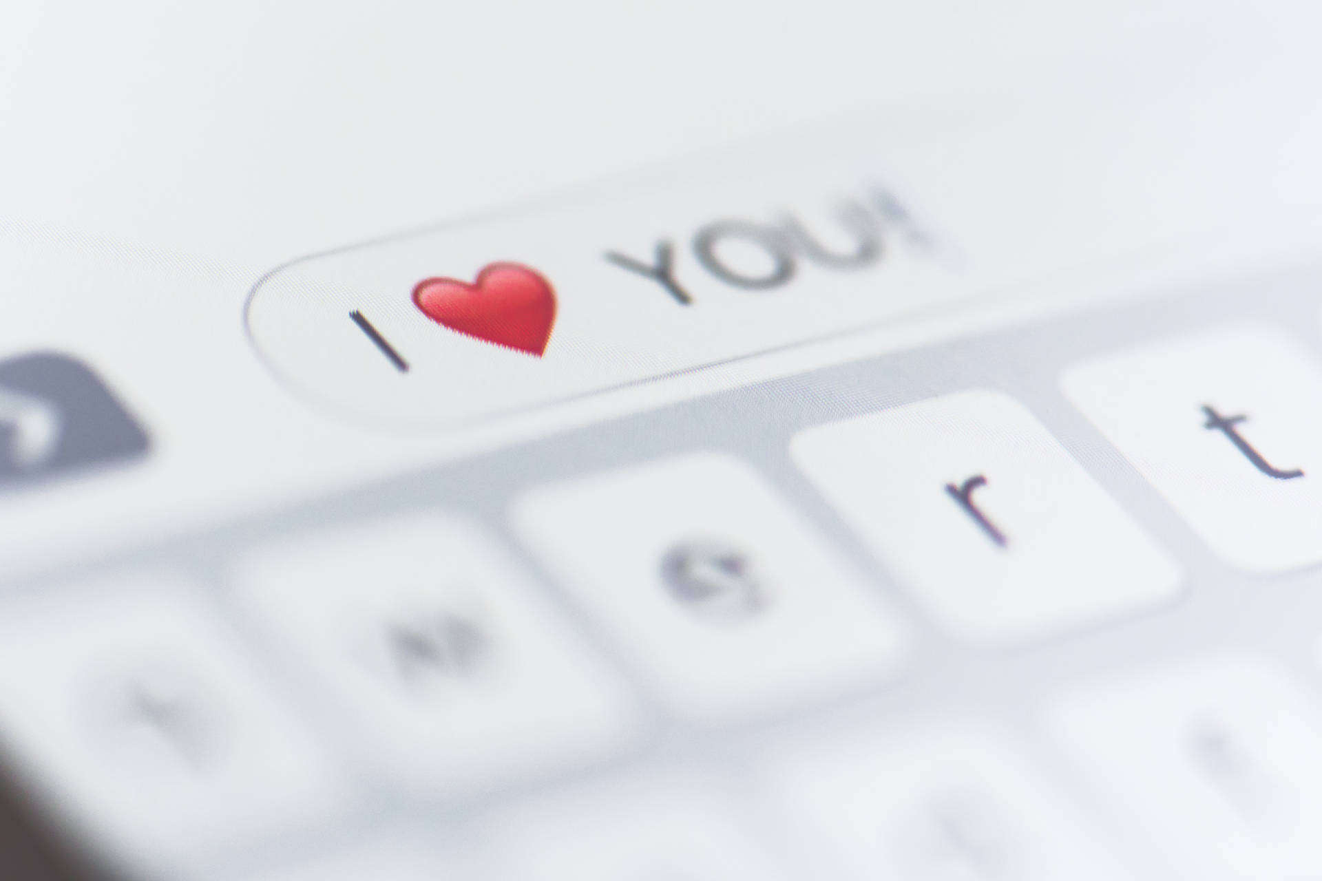 智能手機螢幕顯示一則文字訊息，內容為「I ❤️ YOU!」。