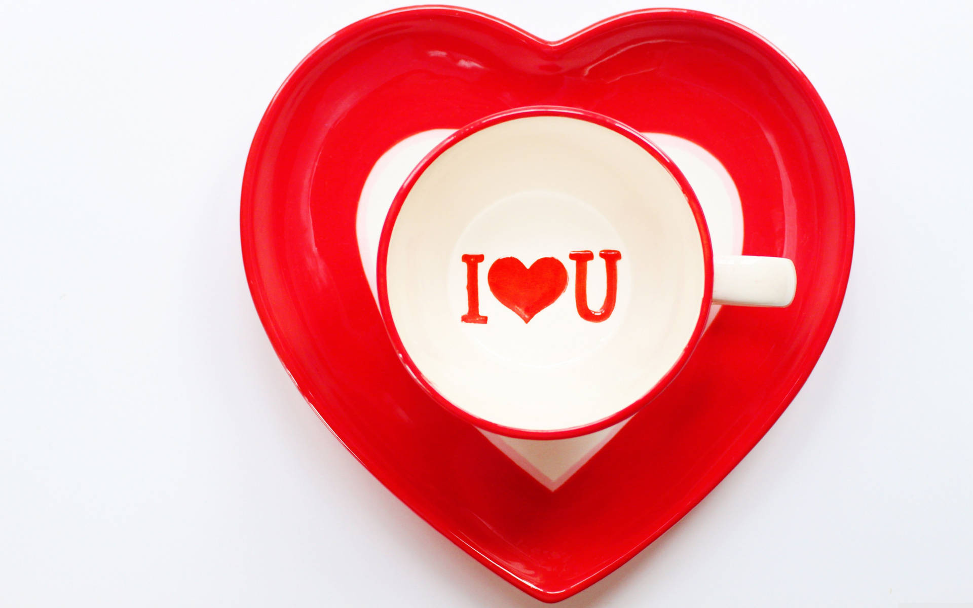 紅色心形碟子托著一個帶有I heart U訊息的白色杯子。