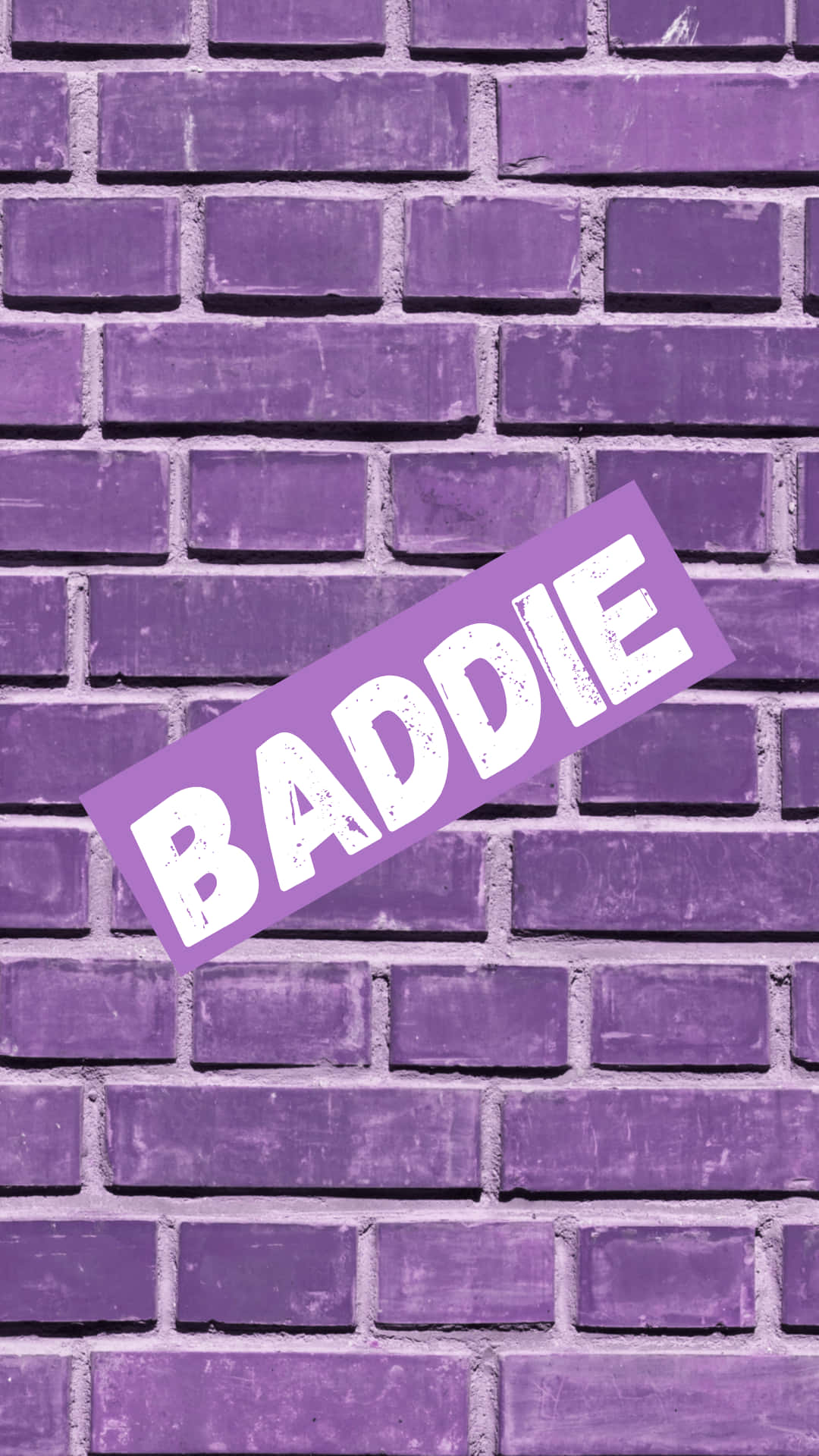 紫色磚牆上有一張傾斜的「BADDIE」貼紙。