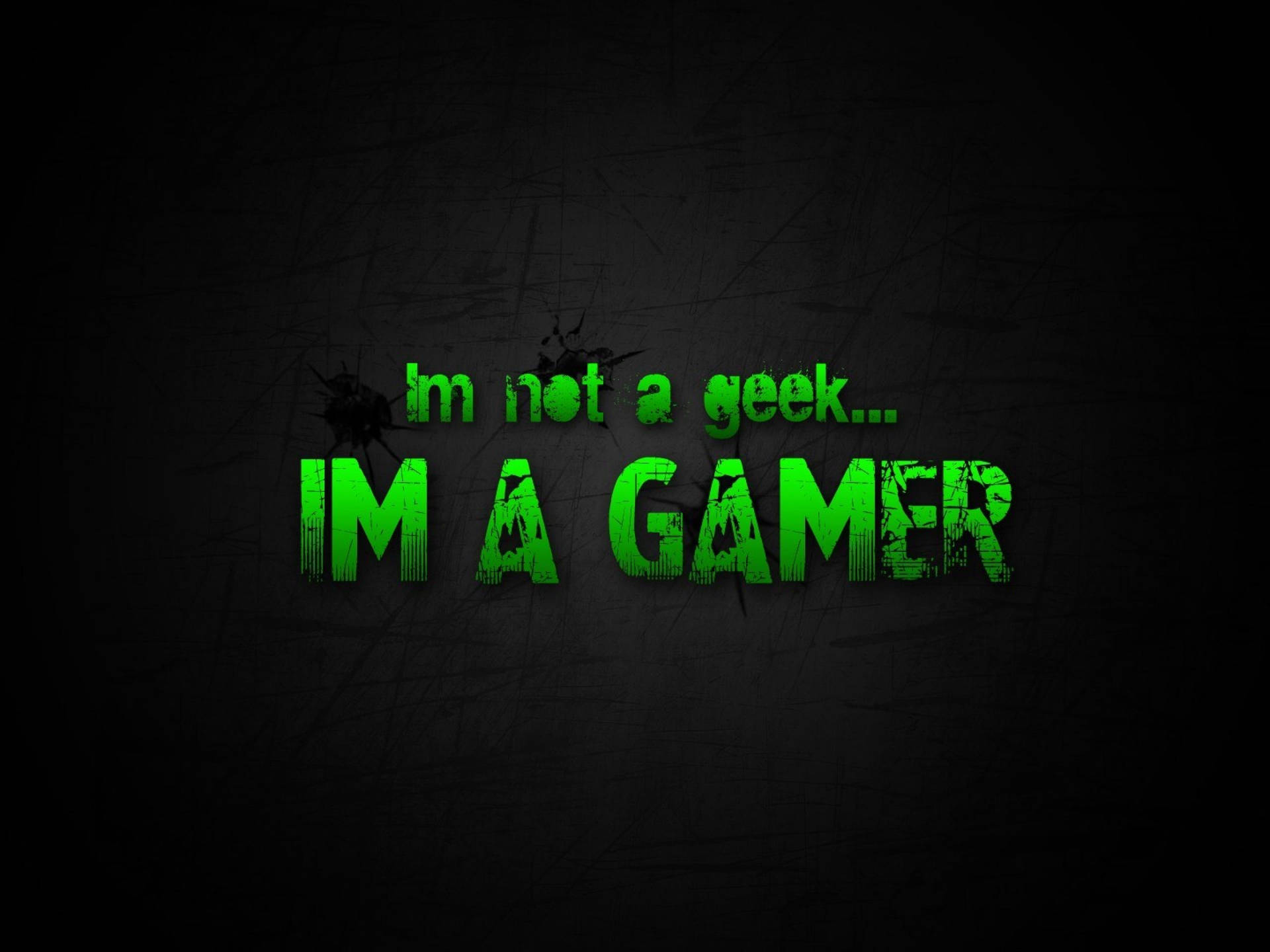綠色文字在刮花的黑色背景上宣告「I'm not a geek... I'M A GAMER」。