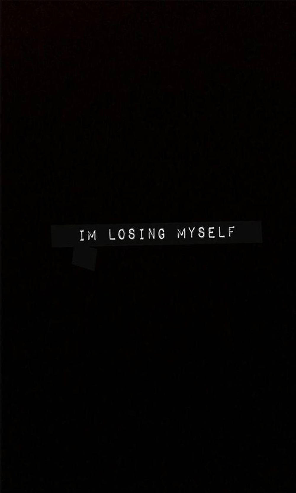 黑色背景上，破爛黑色膠帶上的文字「IM LOSING MYSELF」。