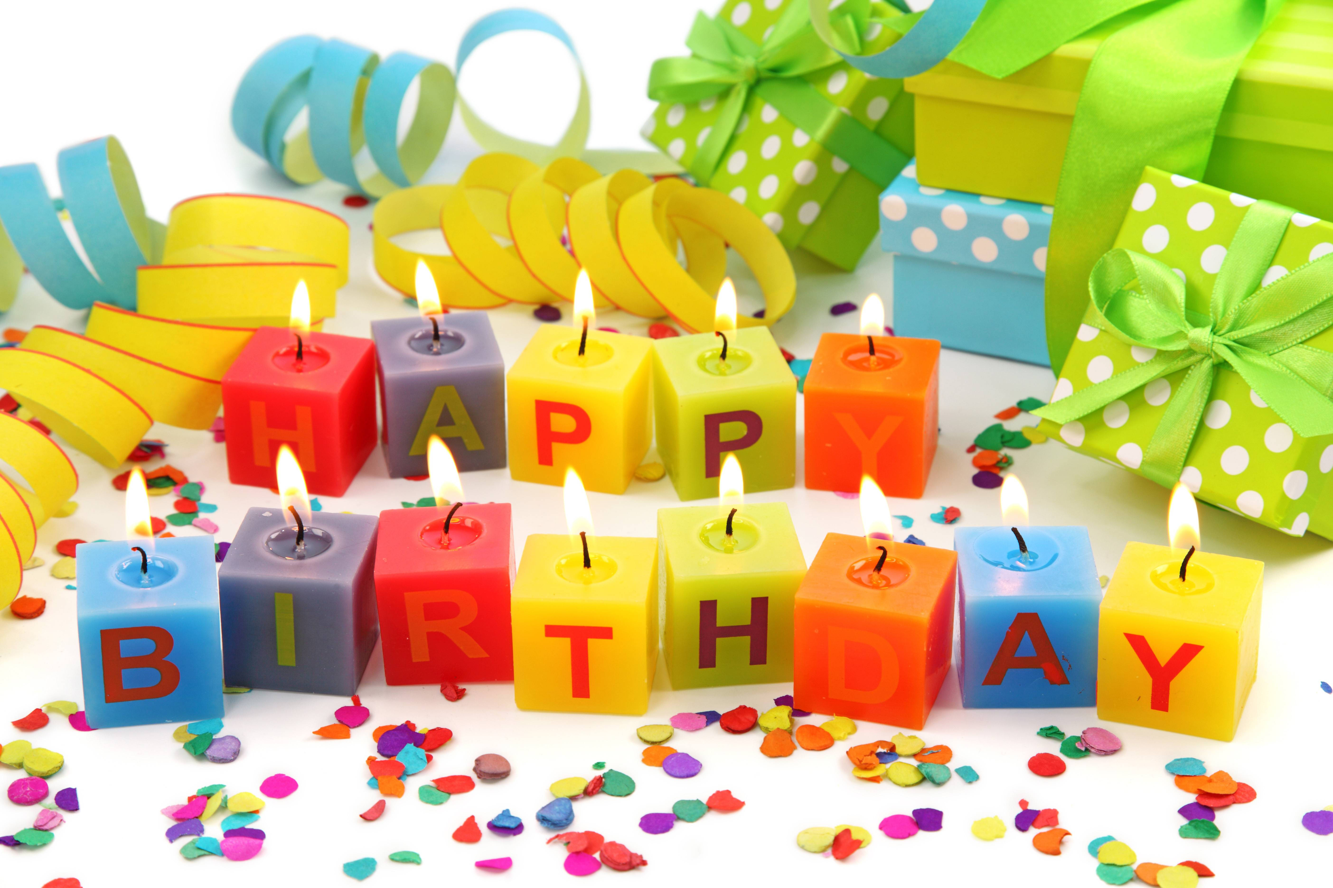 我的生日立方蠟燭 壁紙 — 色彩繽紛的方塊蠟燭拼出 happy birthday，在五彩紙屑和包裝禮物中溫暖地發光。