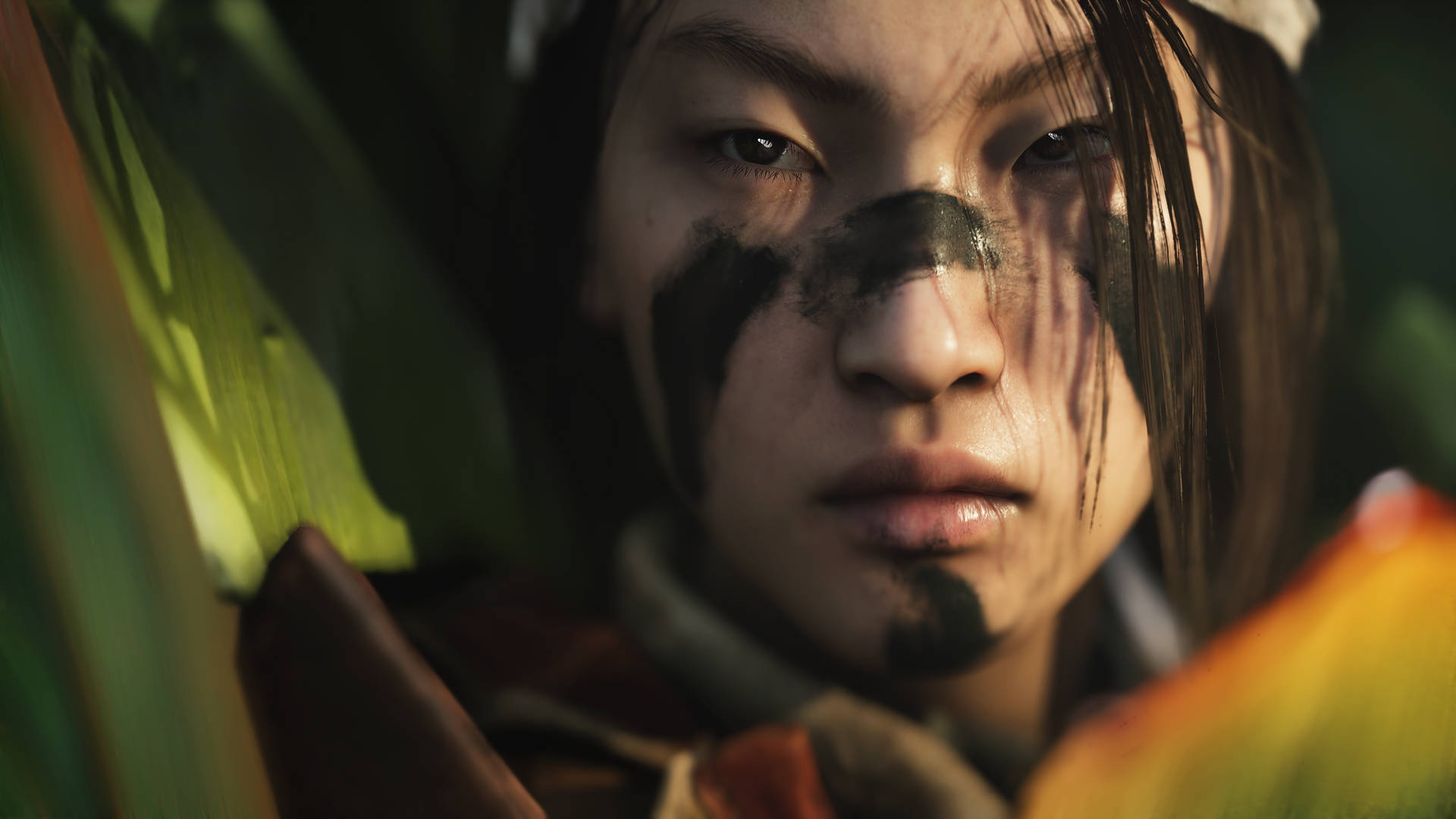 年輕戰士臉上塗有顏料，隱藏在叢林樹葉中