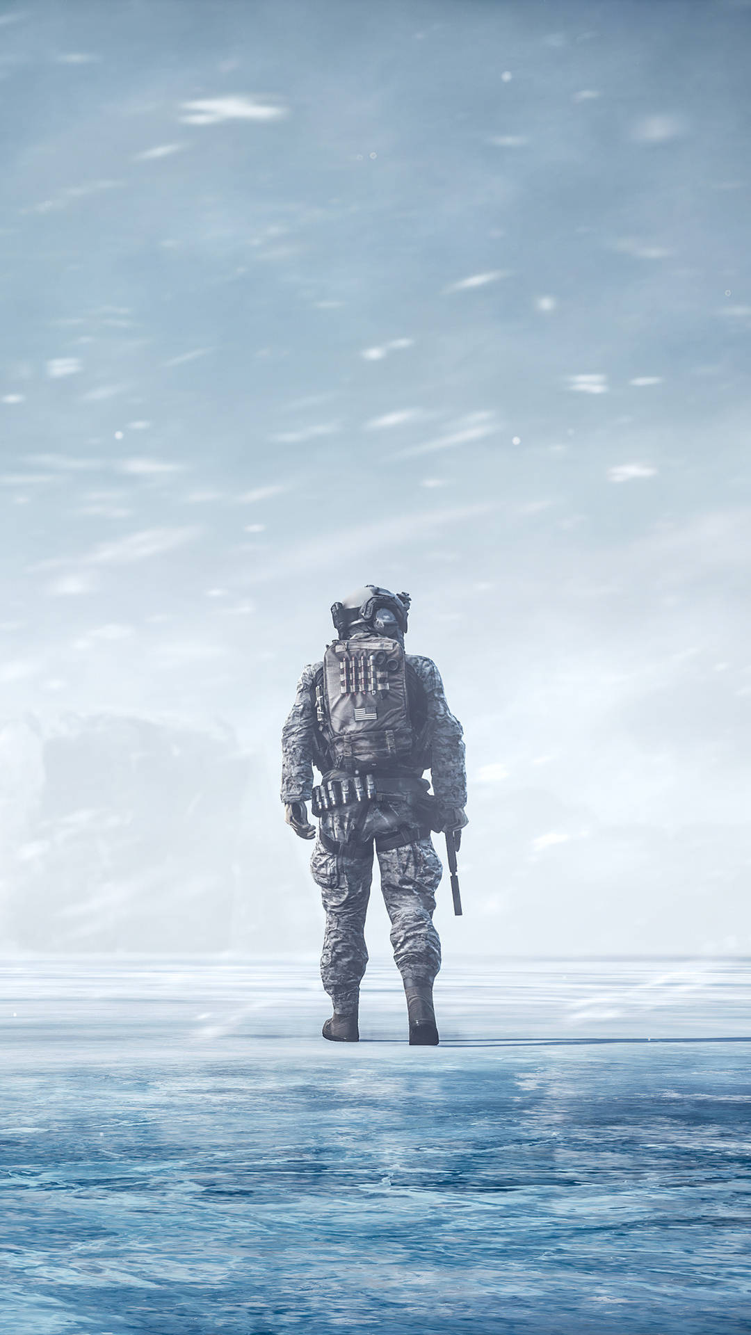 一名穿著冬季裝備的士兵獨自站在降雪中的冰凍景觀上。