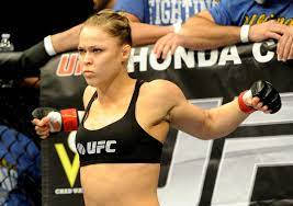 身穿黑色UFC裝備的女性MMA拳手站在八角籠中準備戰鬥。