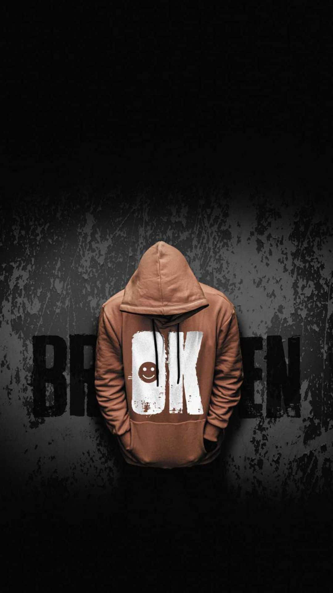 穿著棕色連帽衫、背面有笑臉的人站在黑暗牆壁前，帶有 broken 文字。