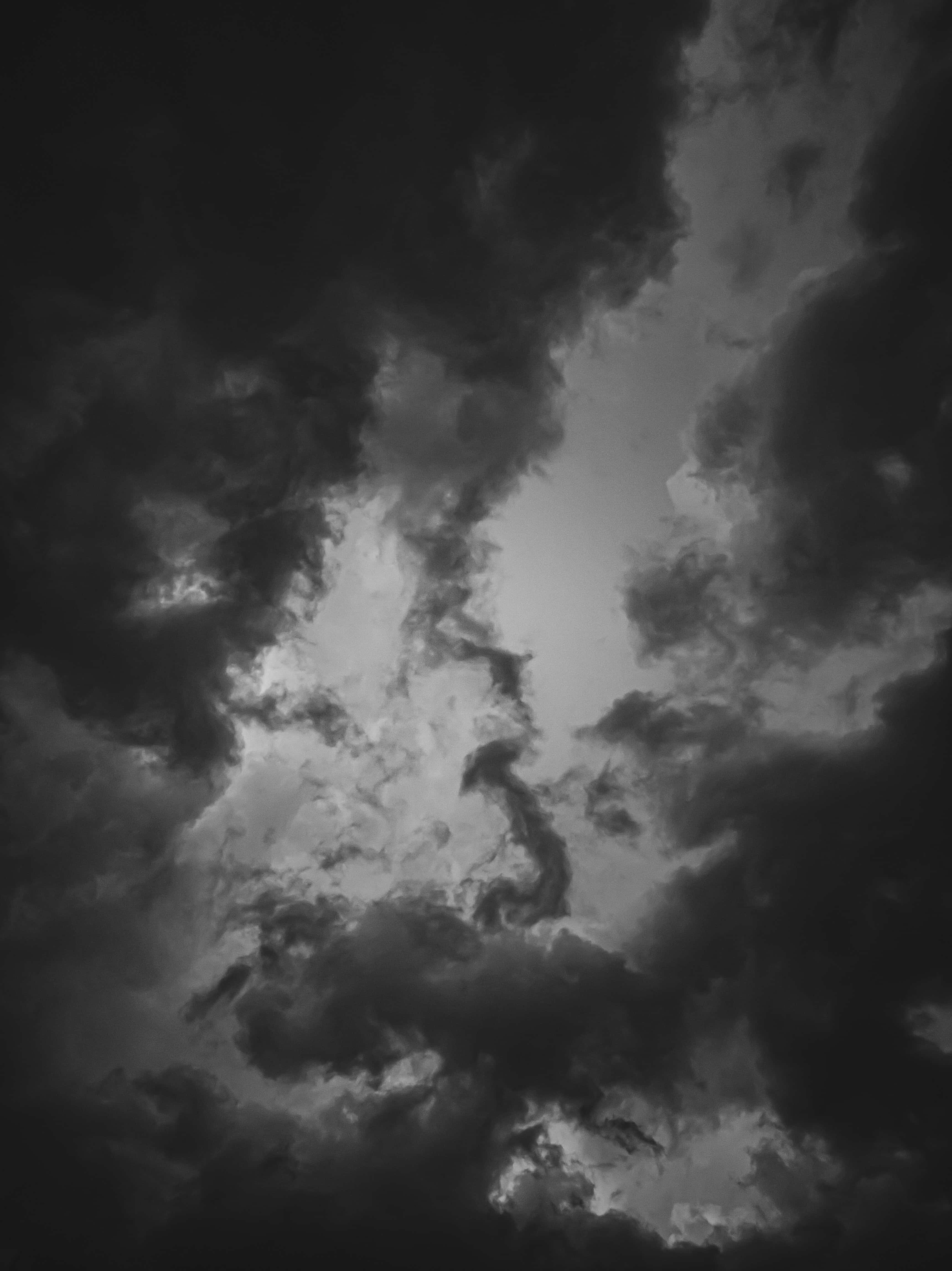 Dark Heaven 桌布 壁紙 — 戲劇性的單色雲在暴風雨的天空中旋轉，強烈的光線穿透濃密的陰影。