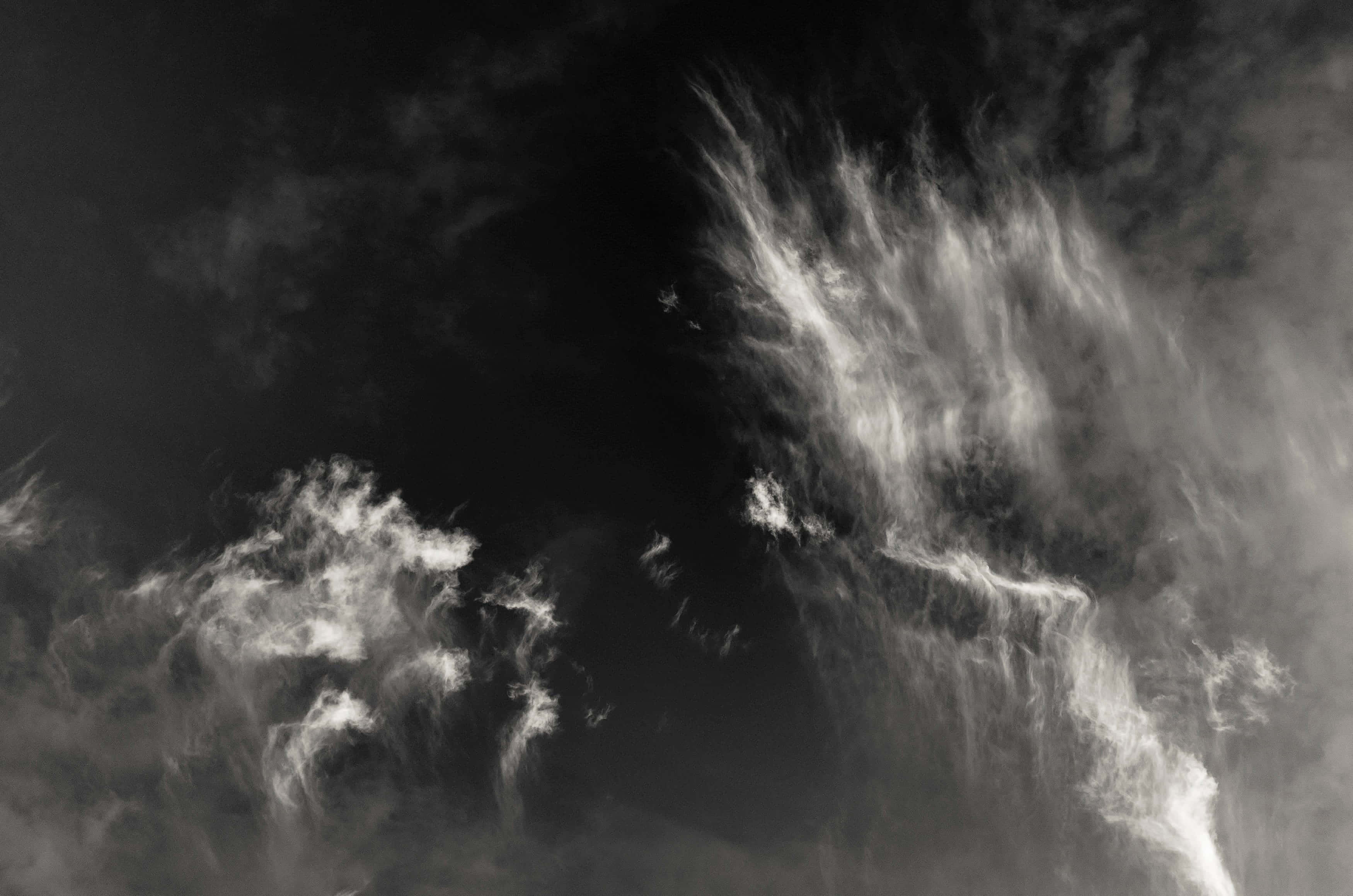 Dark Heaven 桌布 壁紙 — 戲劇性的單色雲層在黑暗的天空中高對比旋轉，營造出陰鬱的氛圍場景。
