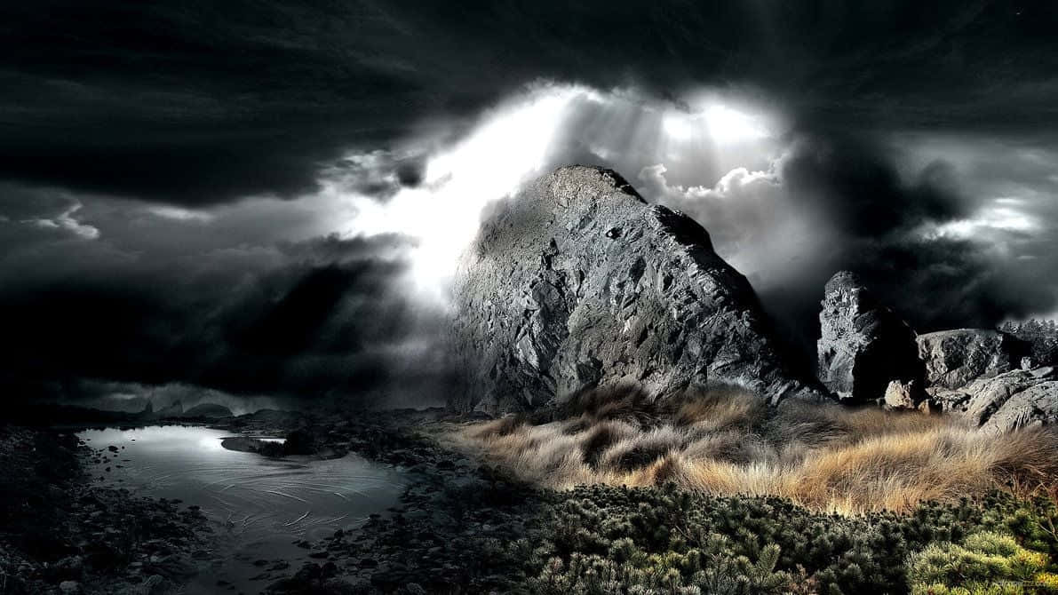 Dark Landscape 桌布 壁紙 — 戲劇性的山峰刺穿暴風雲層，神聖的光芒穿透而出，照亮了下方霧氣瀰漫的湖泊和崎嶇的地形。